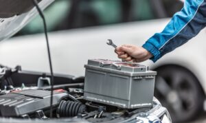 Mechanik kontroluje autobatériu pod kapotou auta – príznaky slabej batérie a jej výmena